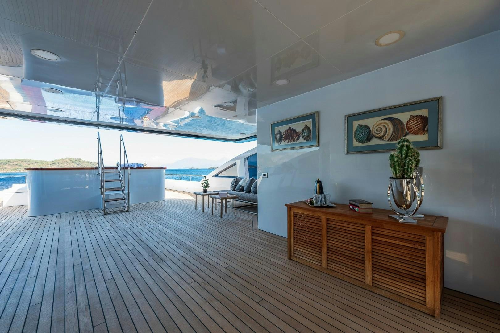 a room with a wood table and a vase with flowers on it aboard OCEAN BREEZE Yacht for Sale