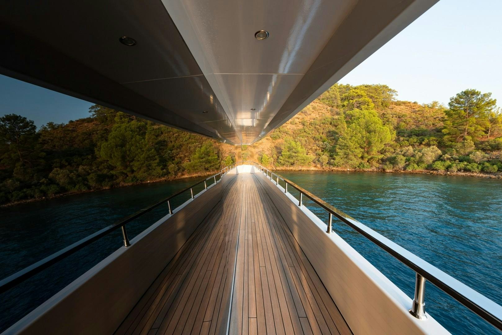 a wooden bridge over a body of water with Sundial Bridge at Turtle Bay in the background aboard OCEAN BREEZE Yacht for Sale