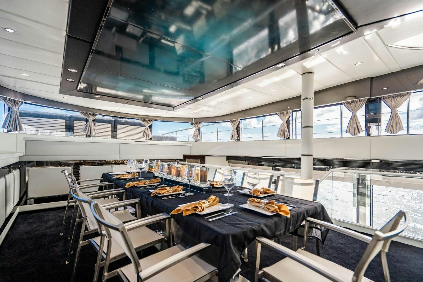a room with tables and chairs aboard PRIVILEGE Yacht for Sale