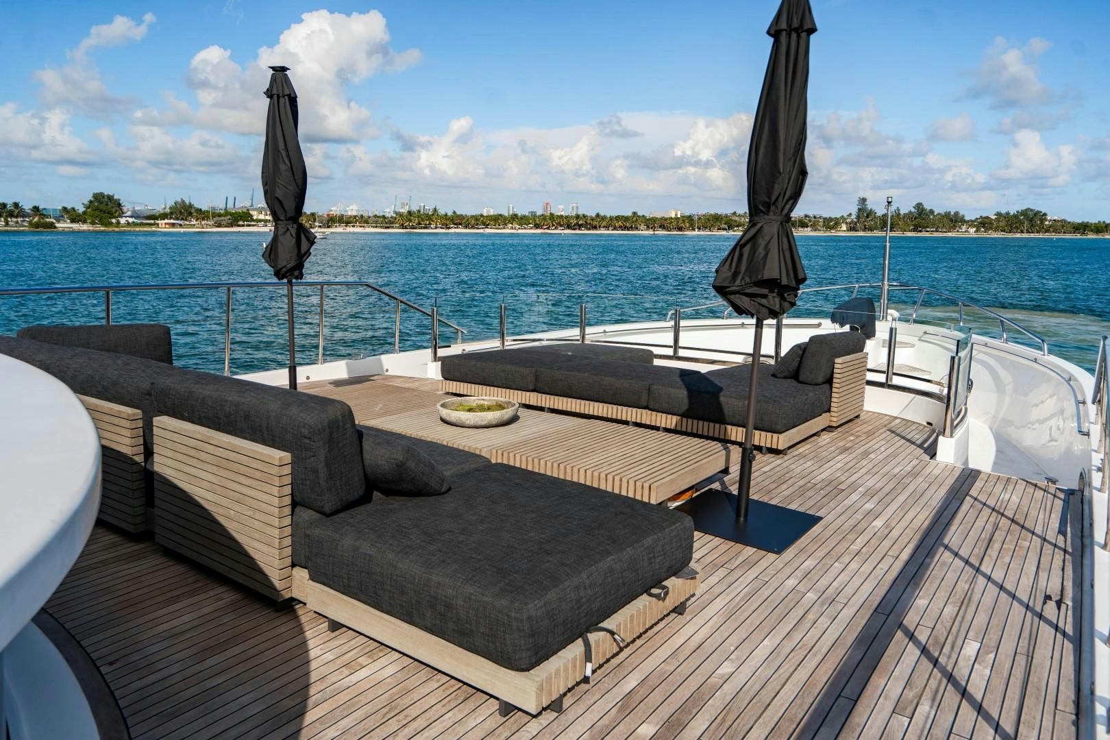 a deck with chairs and a body of water in the background aboard PRIVILEGE Yacht for Sale
