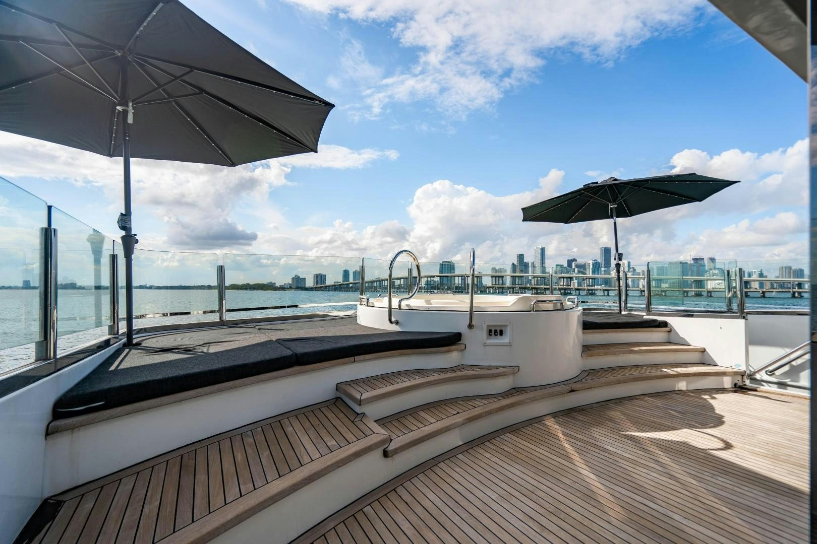 a deck with umbrellas and a view of the water aboard PRIVILEGE Yacht for Sale