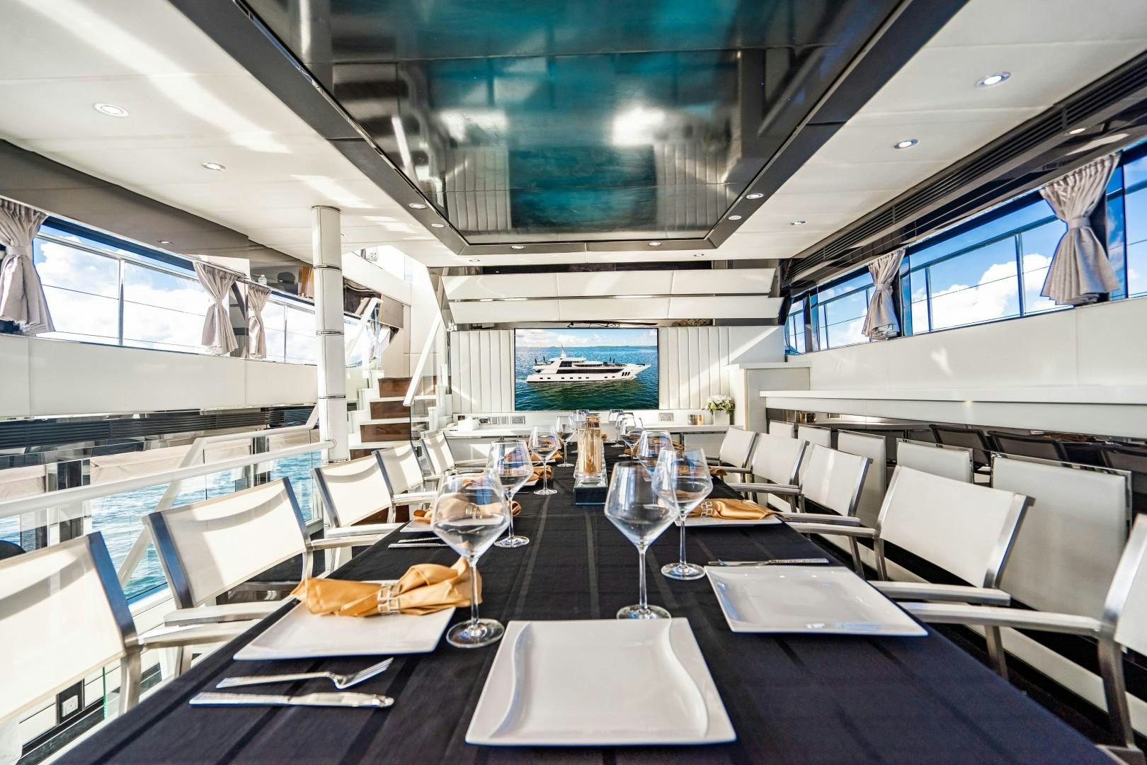 a room with tables and chairs aboard PRIVILEGE Yacht for Sale