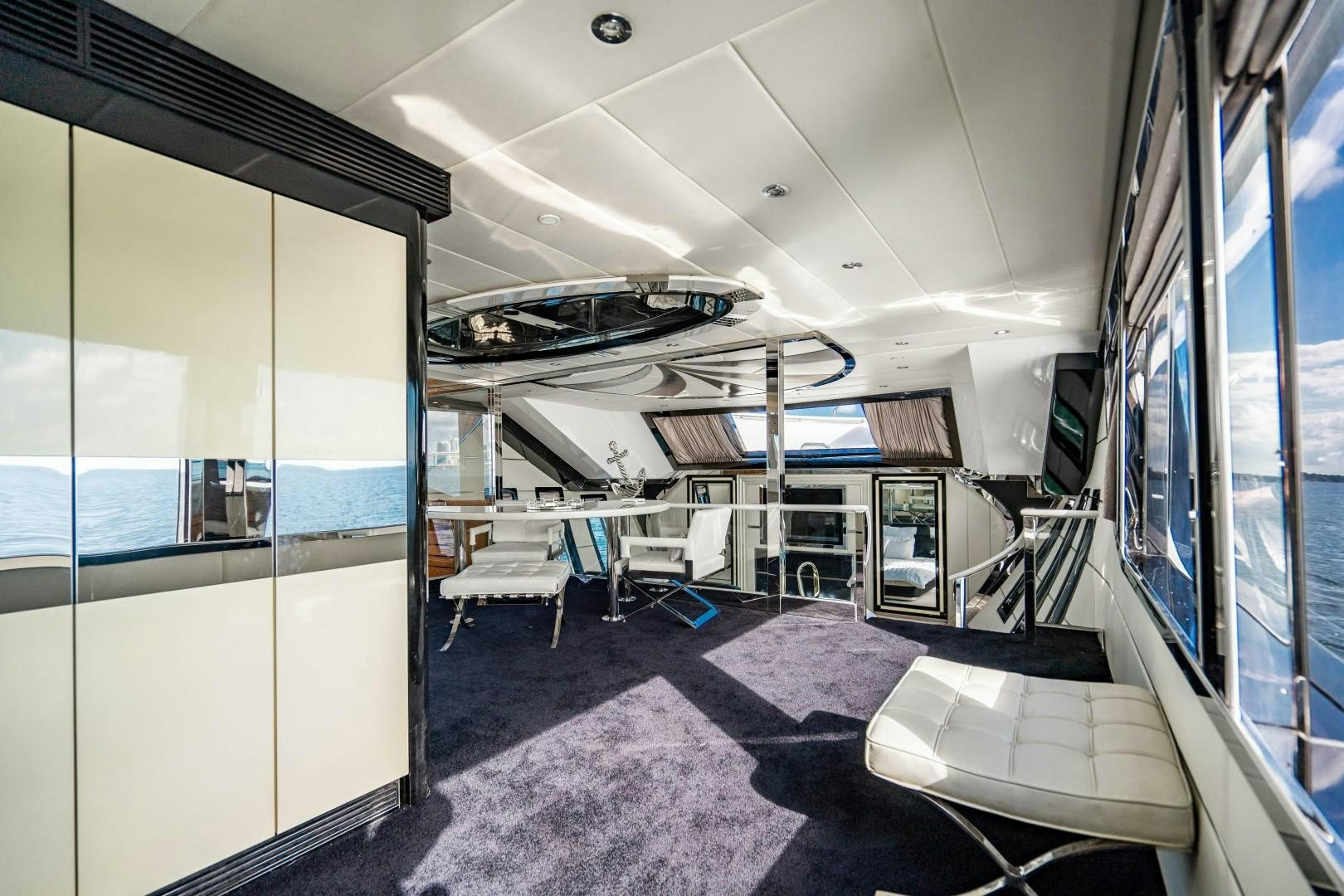 a room with a large window and a table with chairs aboard PRIVILEGE Yacht for Sale