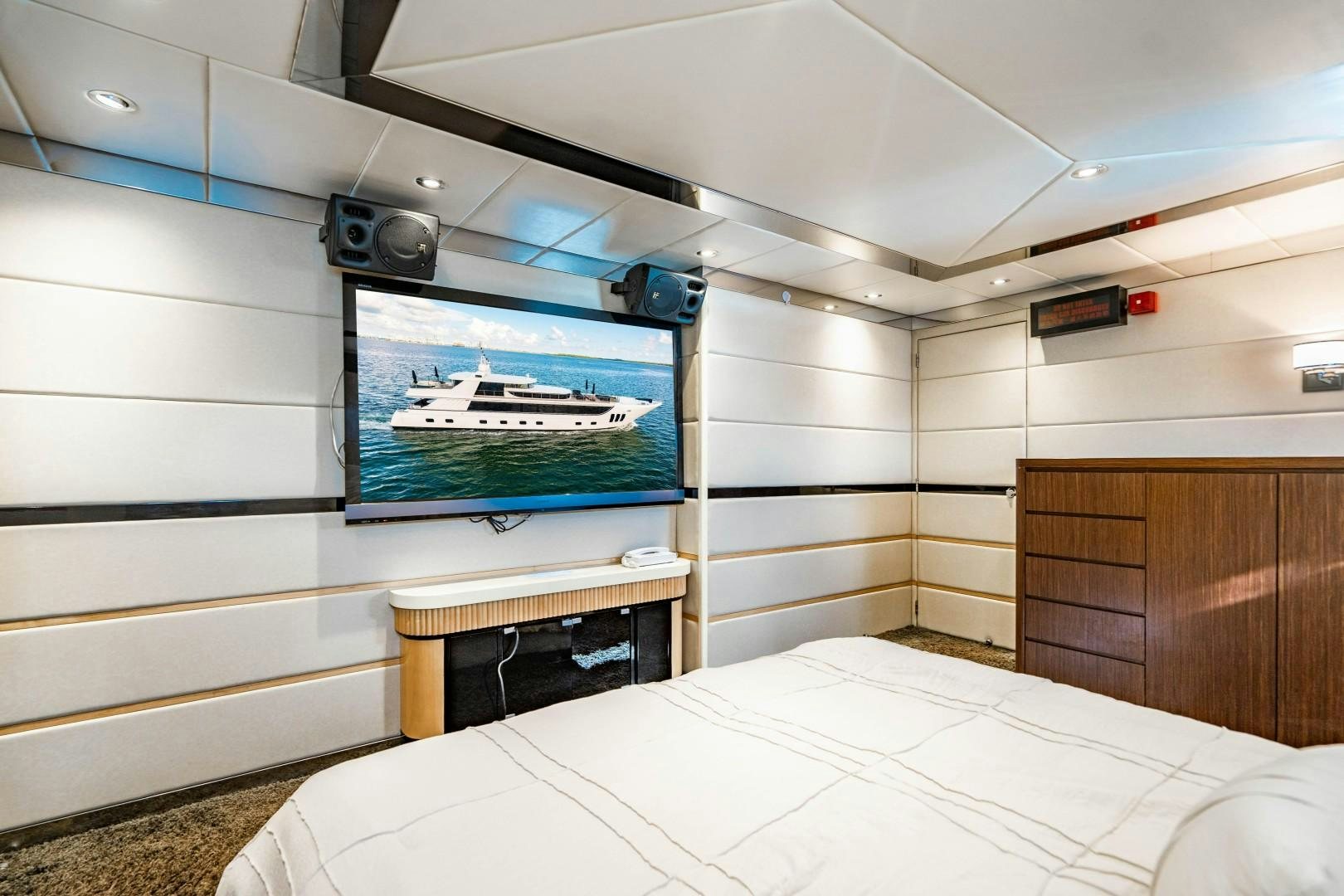 a room with a bed and a television on the wall aboard PRIVILEGE Yacht for Sale
