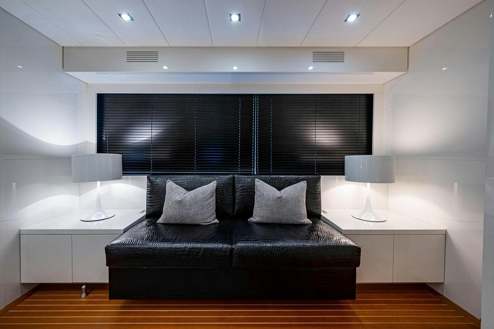 a black couch in a room aboard CASSINELLA Yacht for Sale