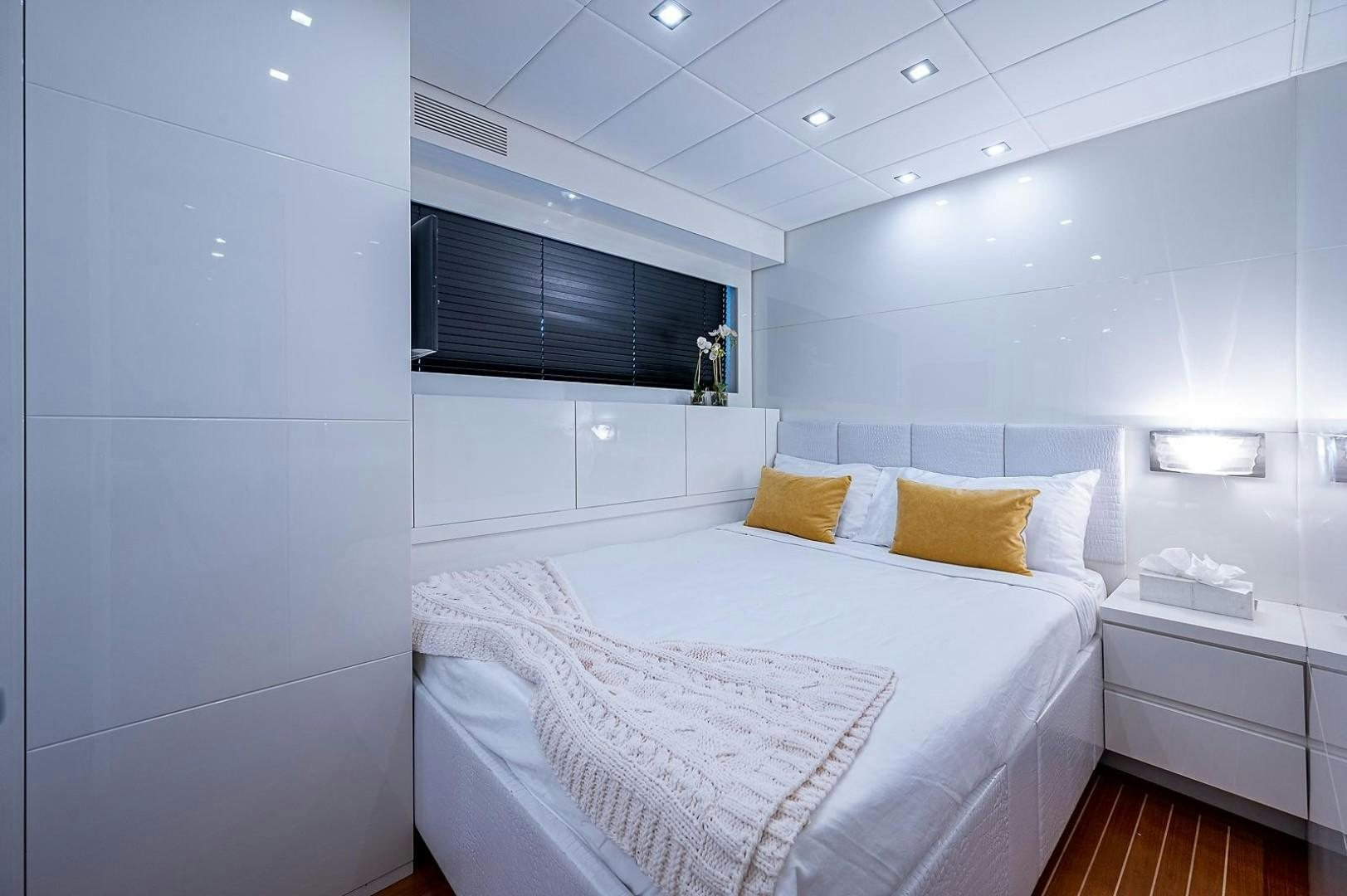 a white bed with yellow pillows aboard CASSINELLA Yacht for Sale