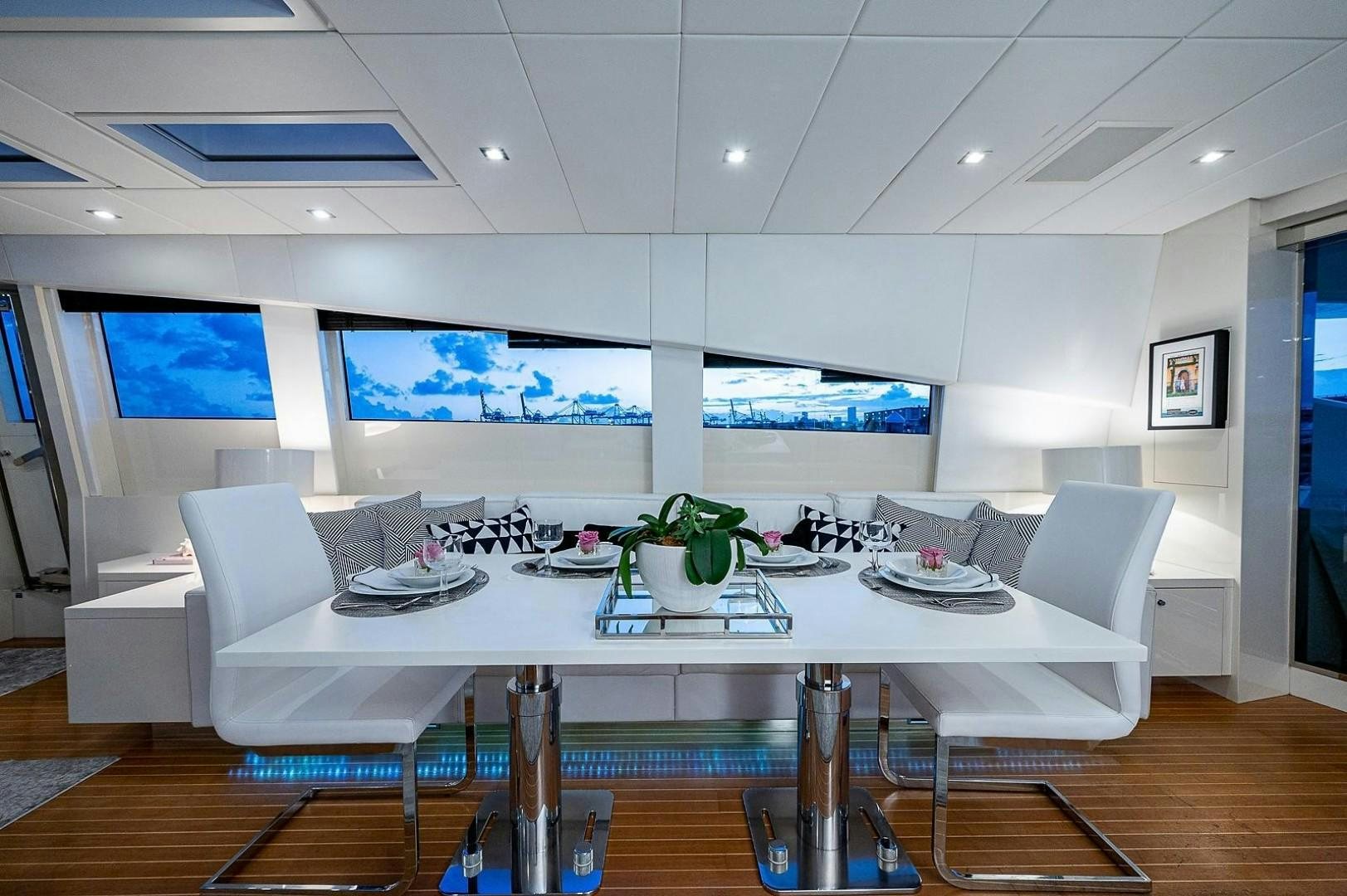 a large room with a table and chairs aboard CASSINELLA Yacht for Sale