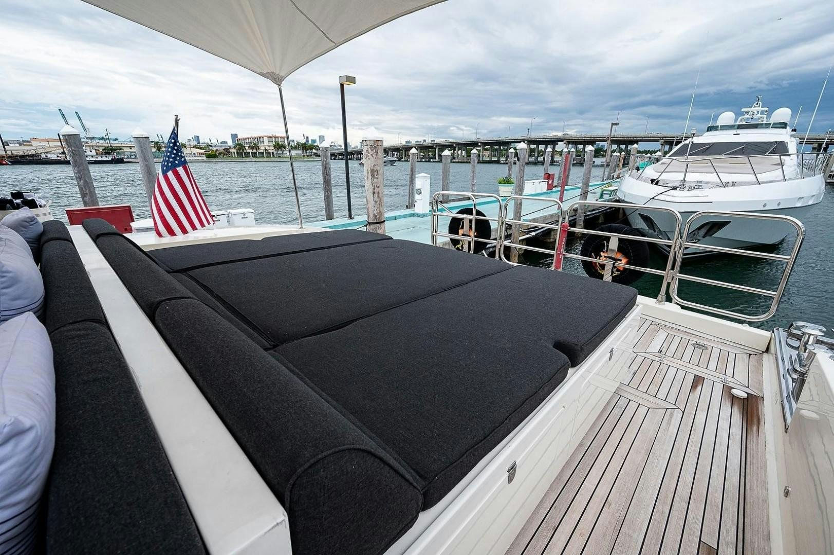 a deck with a flag and boats in the water aboard CASSINELLA Yacht for Sale