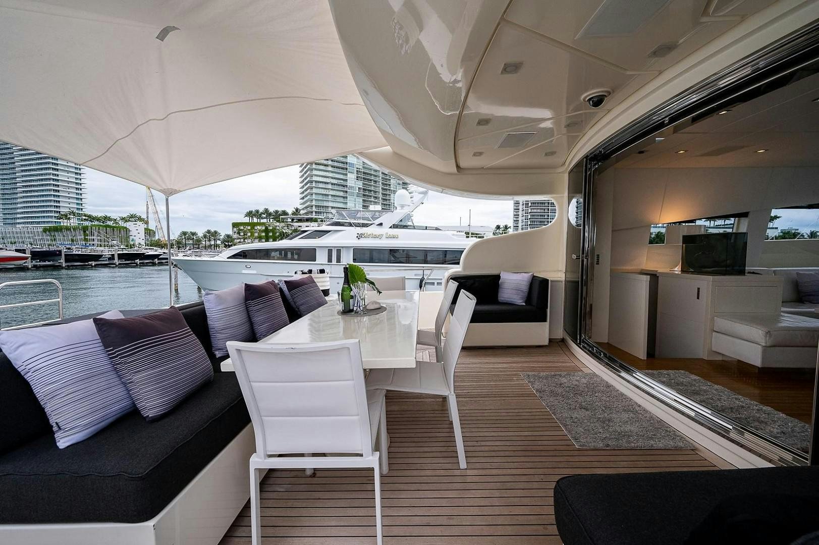 a room with a table chairs and a couch aboard CASSINELLA Yacht for Sale