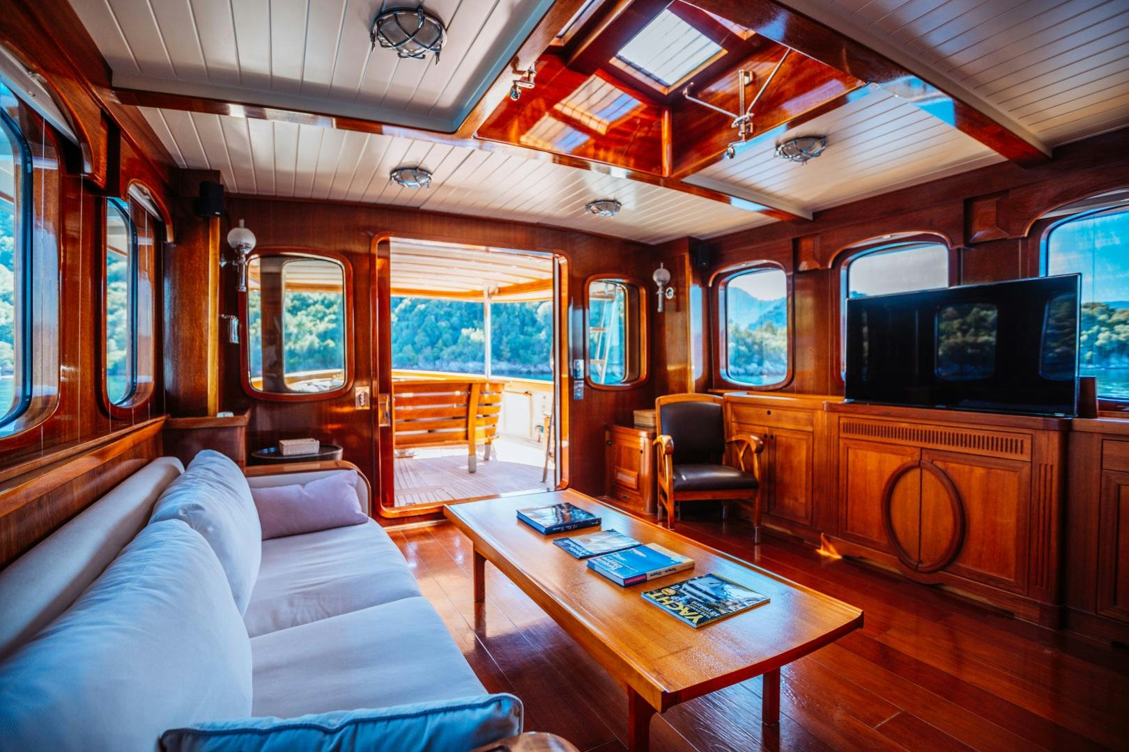 a cabin with a table and couch aboard LARIMAR Yacht for Sale