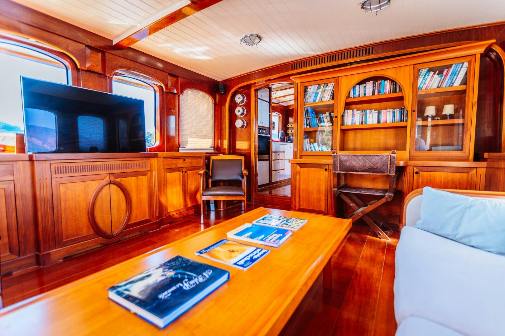 a living room with a tv and bookshelves aboard LARIMAR Yacht for Sale