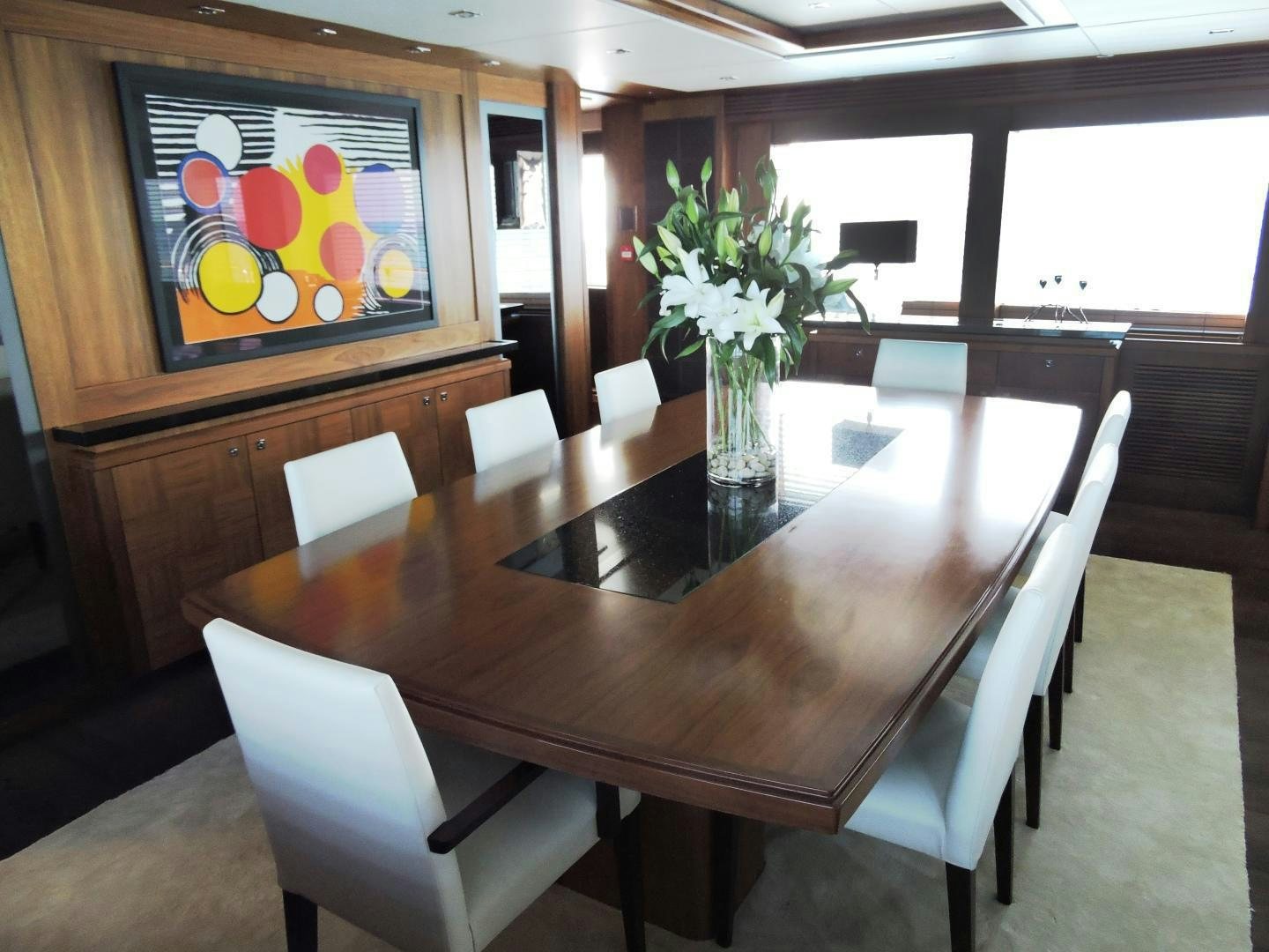 a table with chairs and a vase with flowers on it aboard ACACIA Yacht for Sale