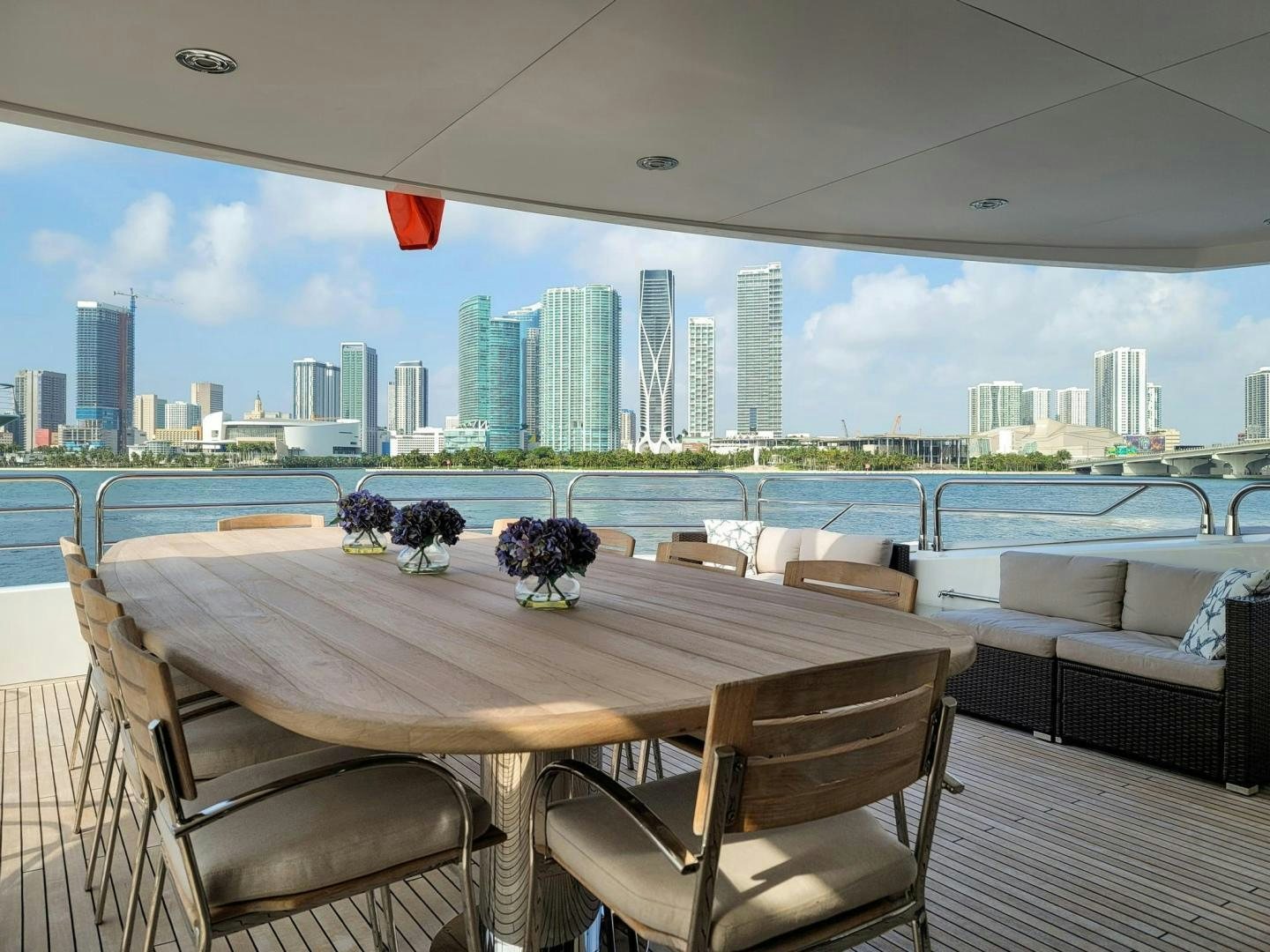 a table with chairs and a view of a city skyline aboard ACACIA Yacht for Sale