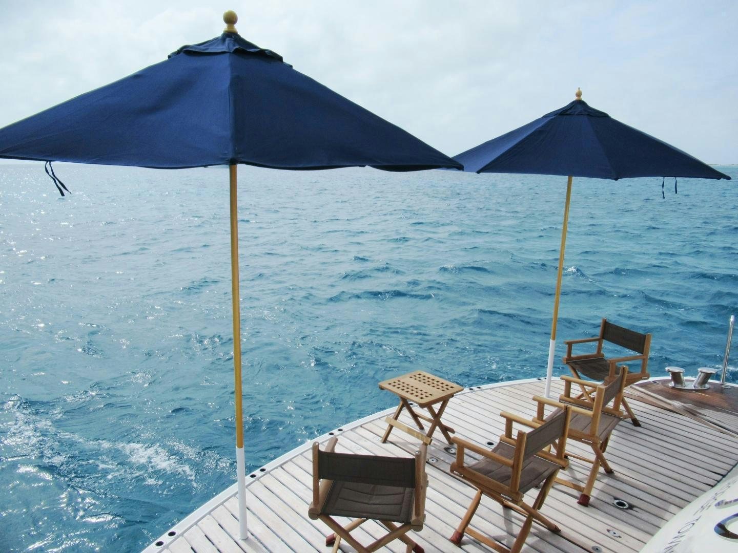 a deck with chairs and umbrellas aboard ACACIA Yacht for Sale