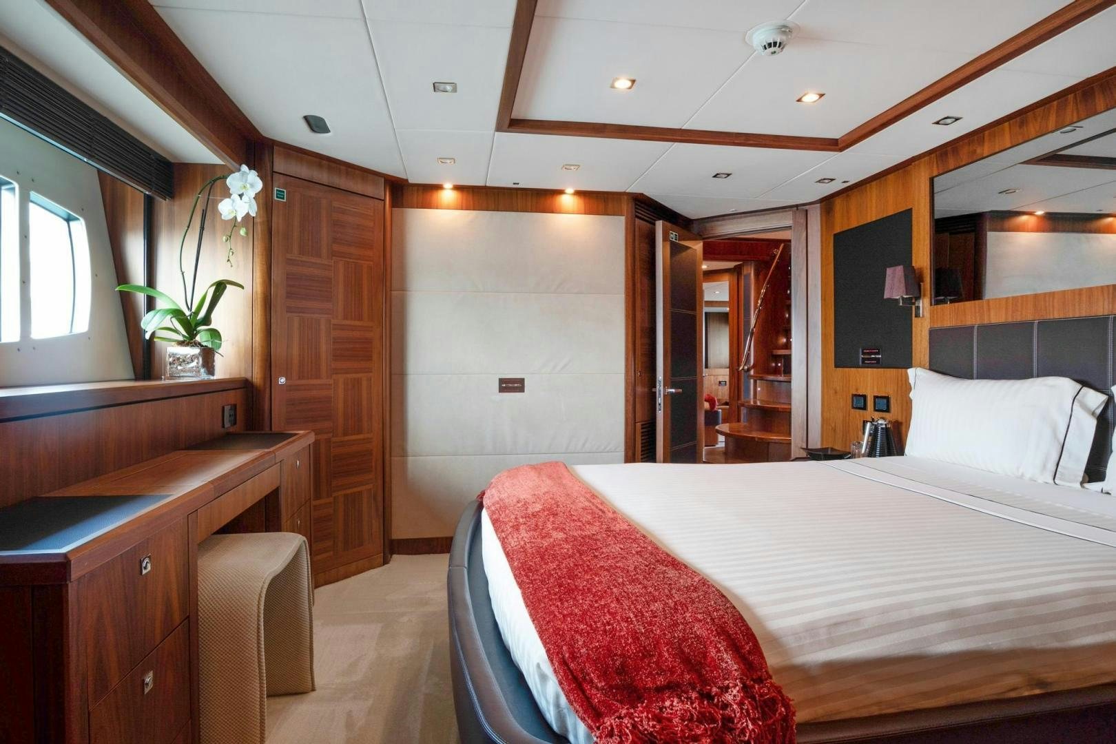 a bedroom with a bed and a desk aboard ACACIA Yacht for Sale
