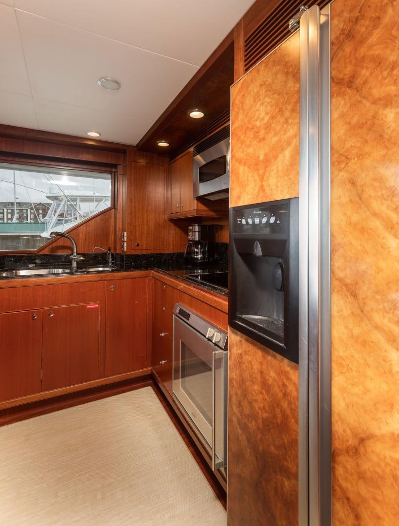 a kitchen with wooden cabinets aboard LADY GIGI Yacht for Sale