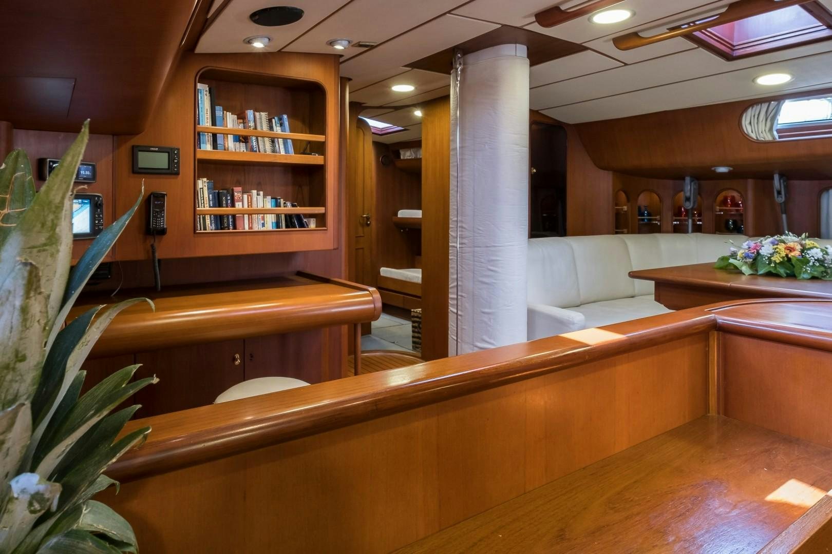 a room with a large white column and a table with flowers aboard ARQUIMEDES Yacht for Sale