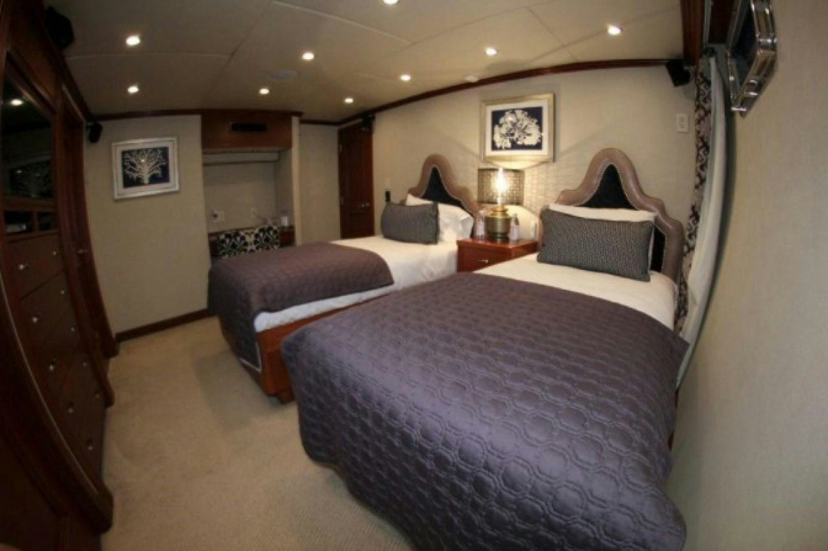 a room with three beds aboard HURACAN Yacht for Sale
