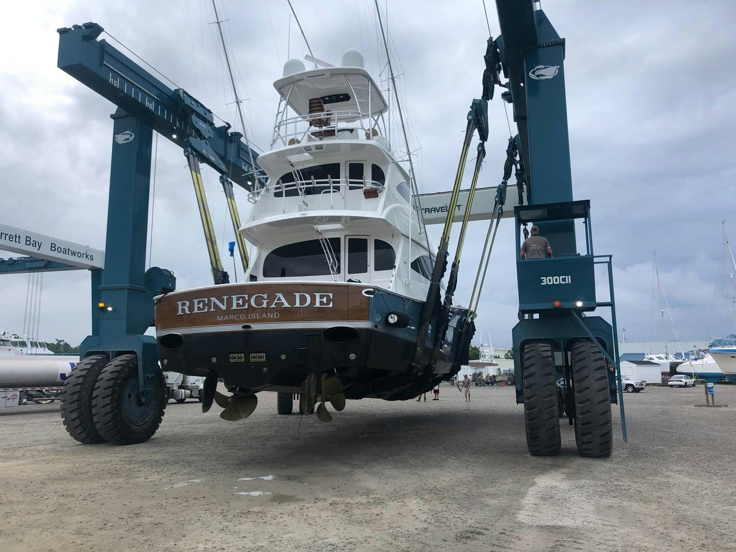 a large crane lifting a large boat aboard Renegade Yacht for Sale