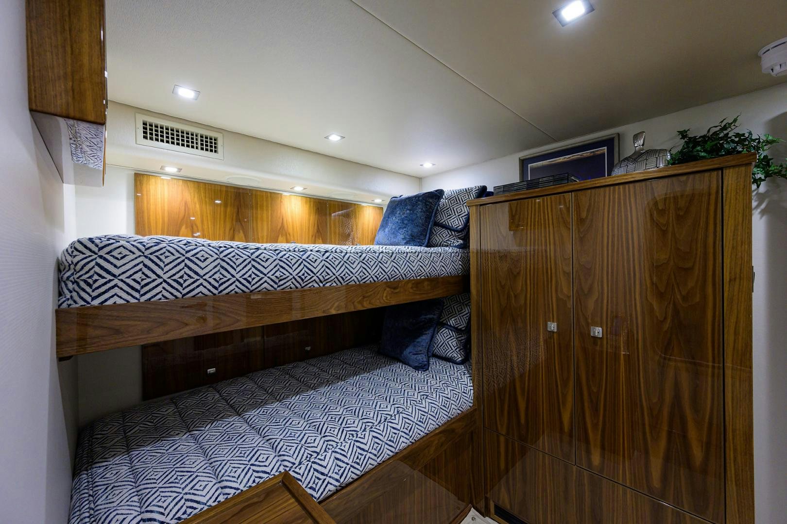 a bedroom with a bed and a wood cabinet aboard Renegade Yacht for Sale