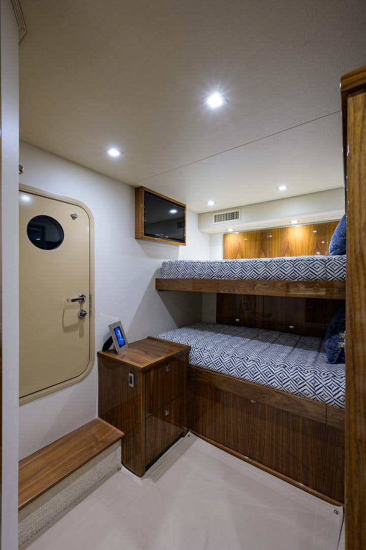 a bedroom with a bed and a tv on the wall aboard Renegade Yacht for Sale