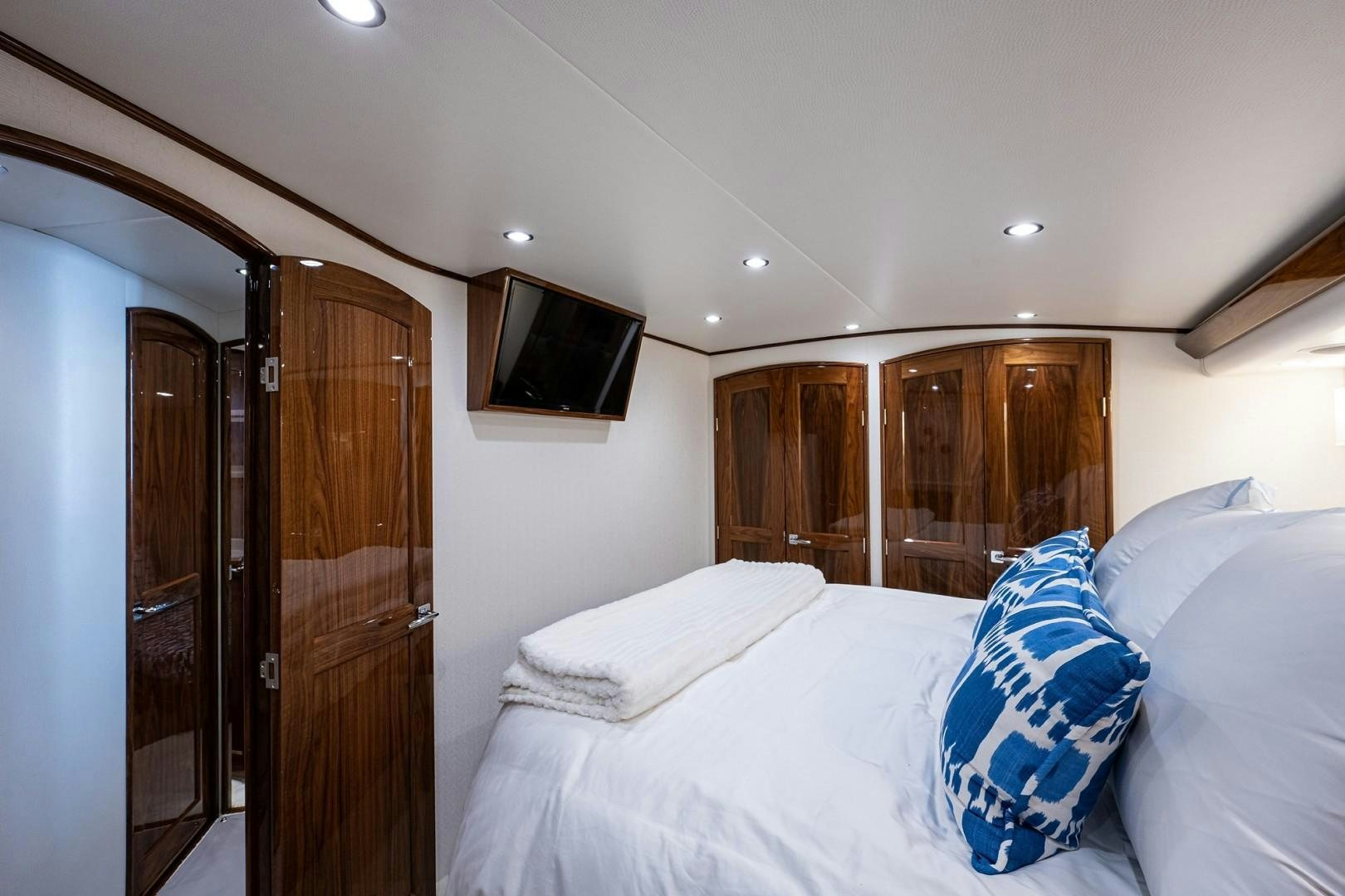 a bedroom with a bed and a television aboard REEL CRAZY Yacht for Sale