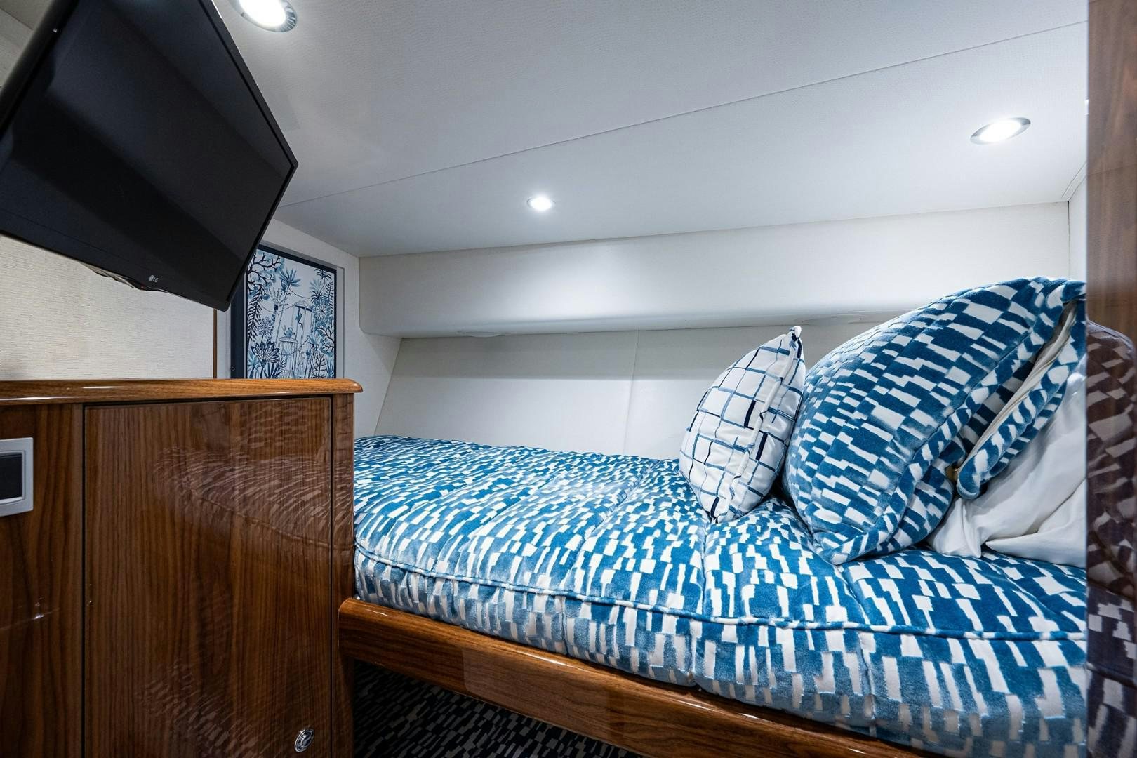 a bed with blue and white sheets aboard REEL CRAZY Yacht for Sale