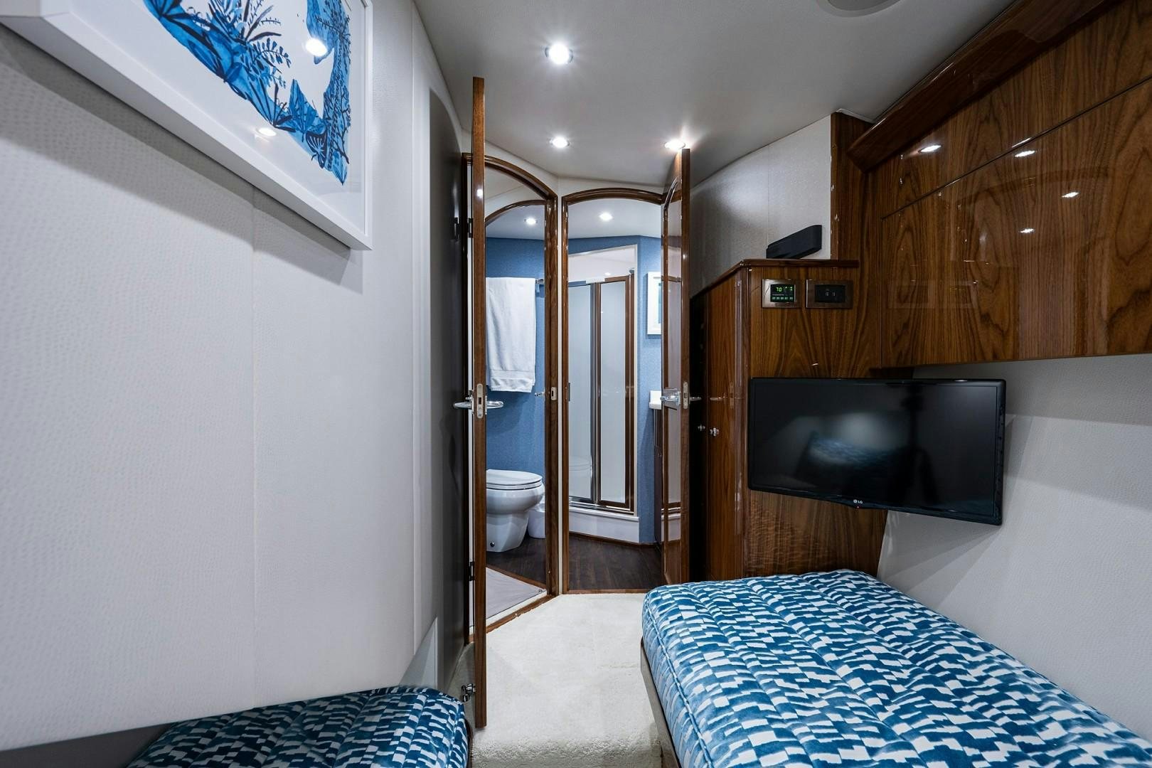 a bedroom with a bed and a television aboard REEL CRAZY Yacht for Sale