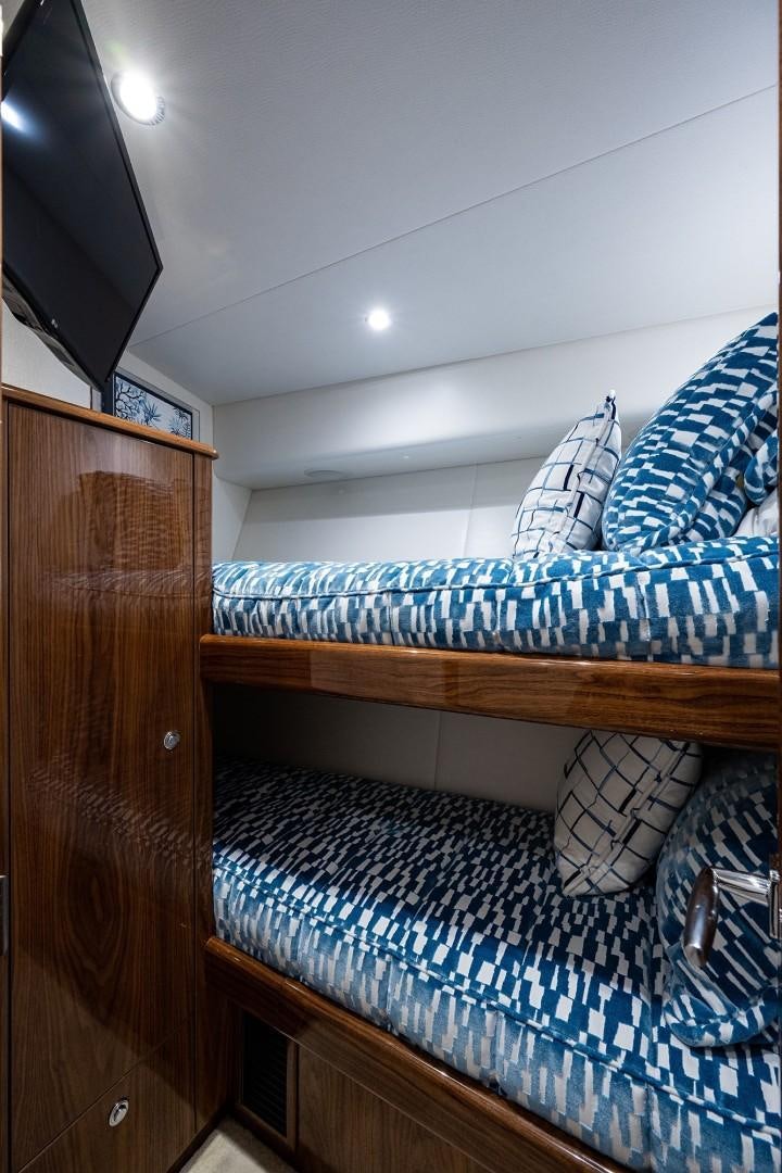 a bed with a blue and white striped blanket aboard REEL CRAZY Yacht for Sale