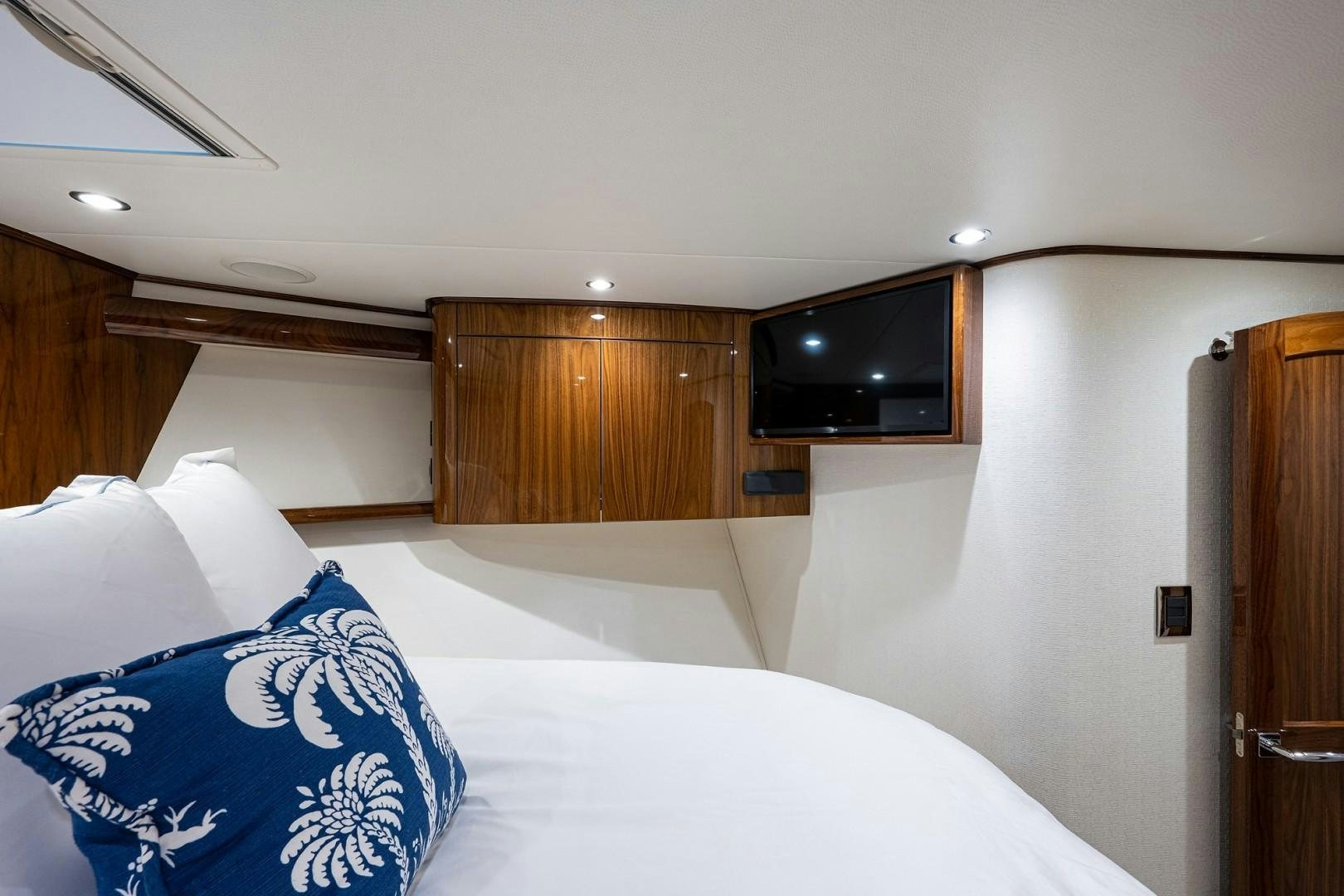 a bedroom with a bed and a television aboard REEL CRAZY Yacht for Sale