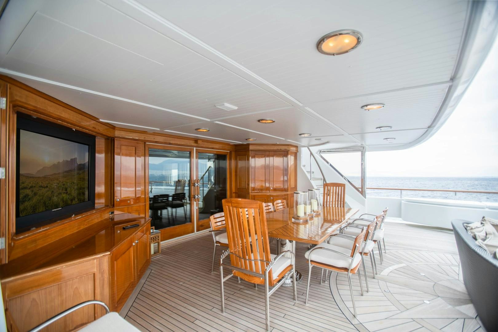 a room with a table chairs and a television aboard FARIBANA V Yacht for Sale