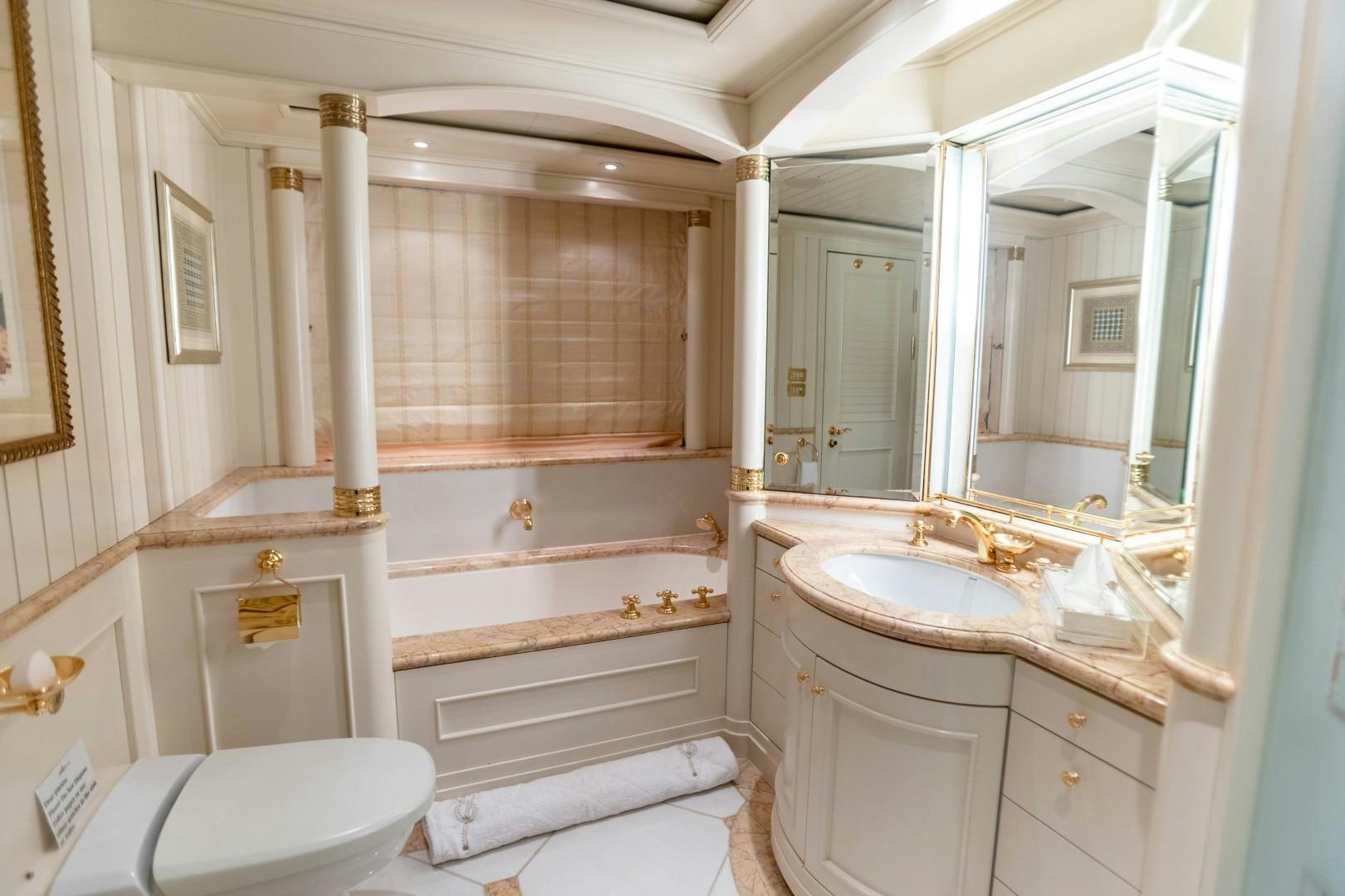 a bathroom with a tub sink and toilet aboard FARIBANA V Yacht for Sale