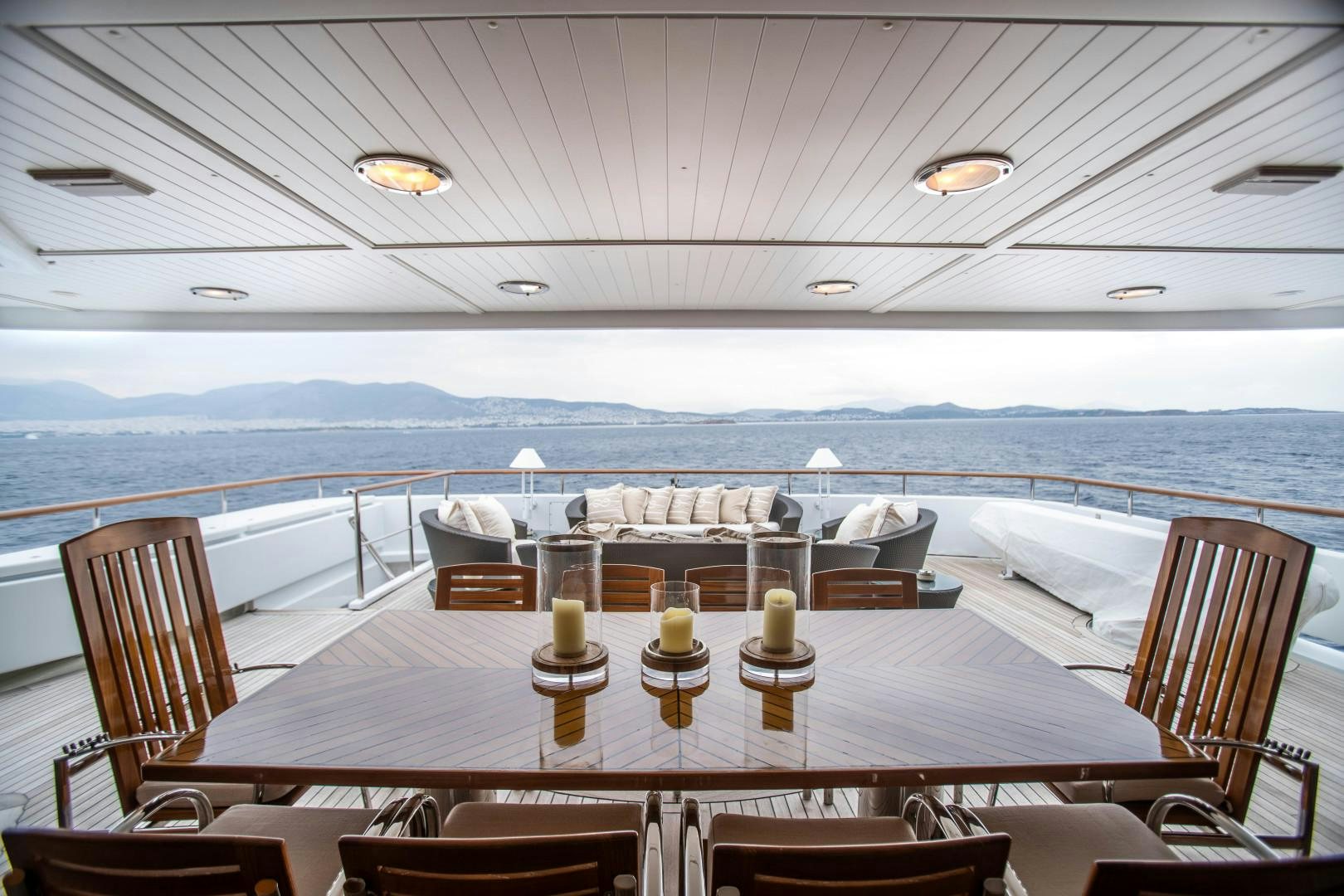 a table with chairs and a view of the ocean aboard FARIBANA V Yacht for Sale