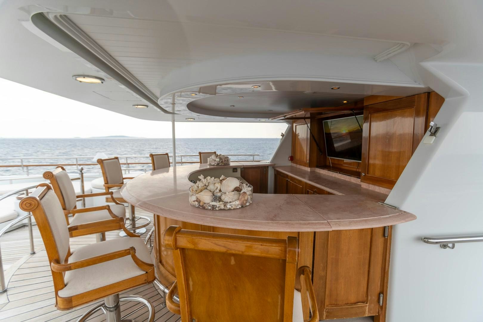 a table with chairs and a television on it aboard FARIBANA V Yacht for Sale