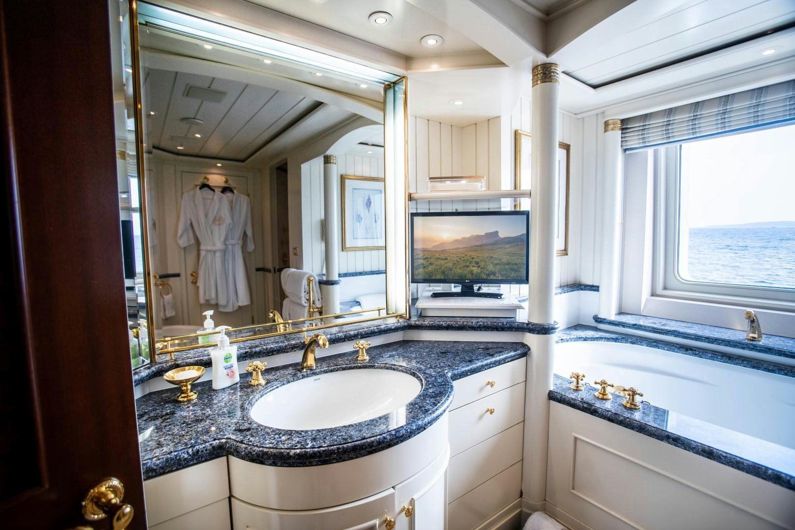a bathroom with a sink and a large mirror aboard FARIBANA V Yacht for Sale