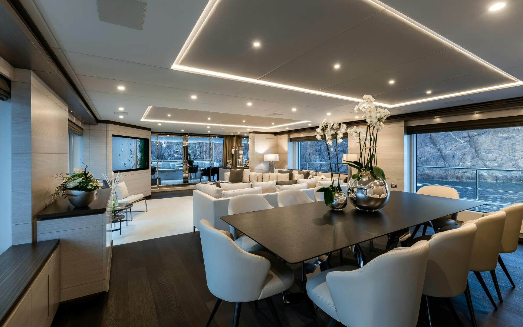 a large room with white chairs and a large table with plants in it aboard JACOZAMI Yacht for Sale