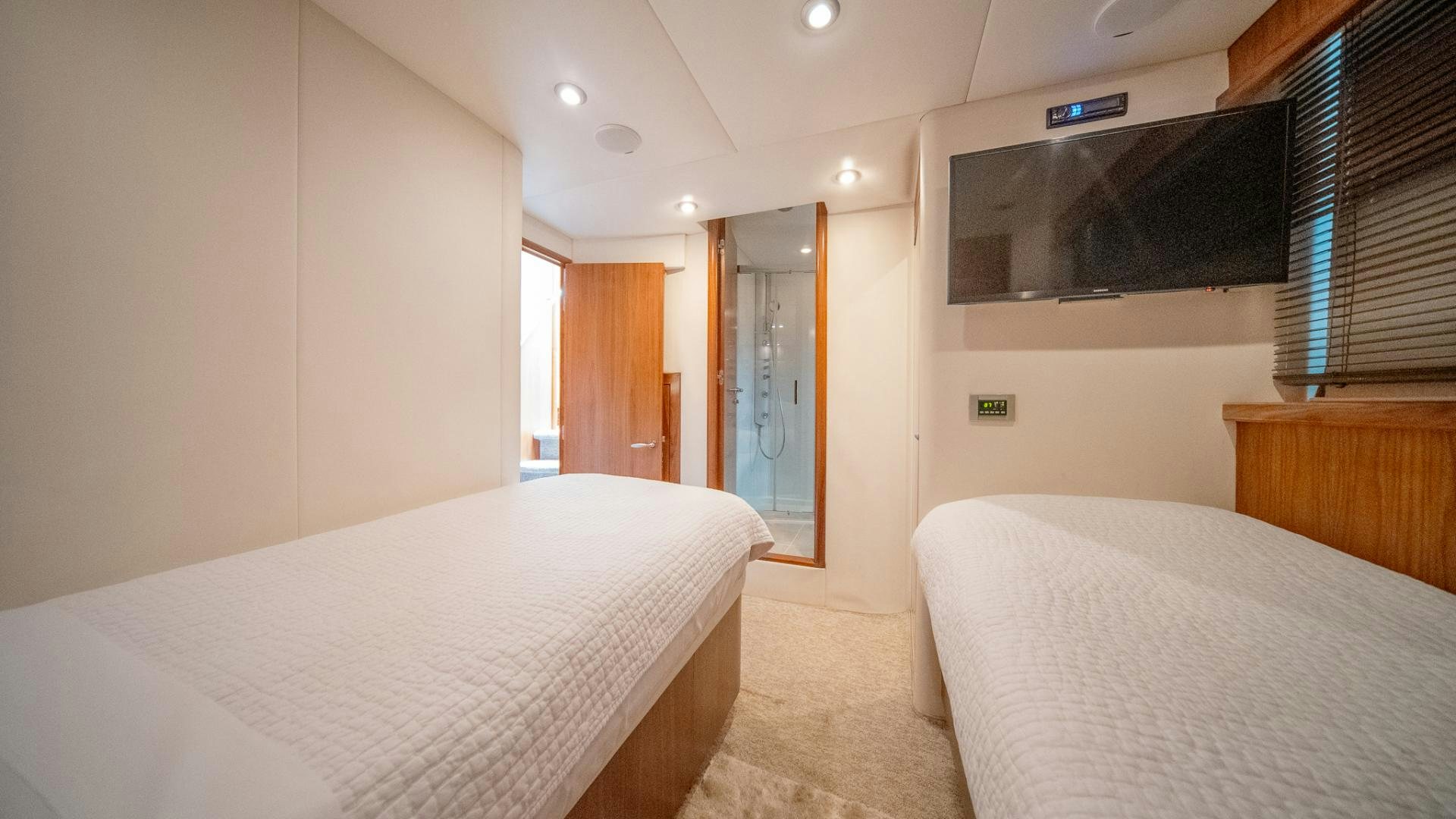 a room with a bed and a television on the wall aboard GOOD LACK Yacht for Sale