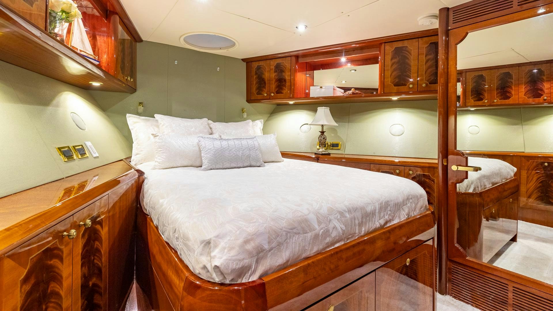a bedroom with a bed and a mirror aboard HOPE FLOATS Yacht for Sale