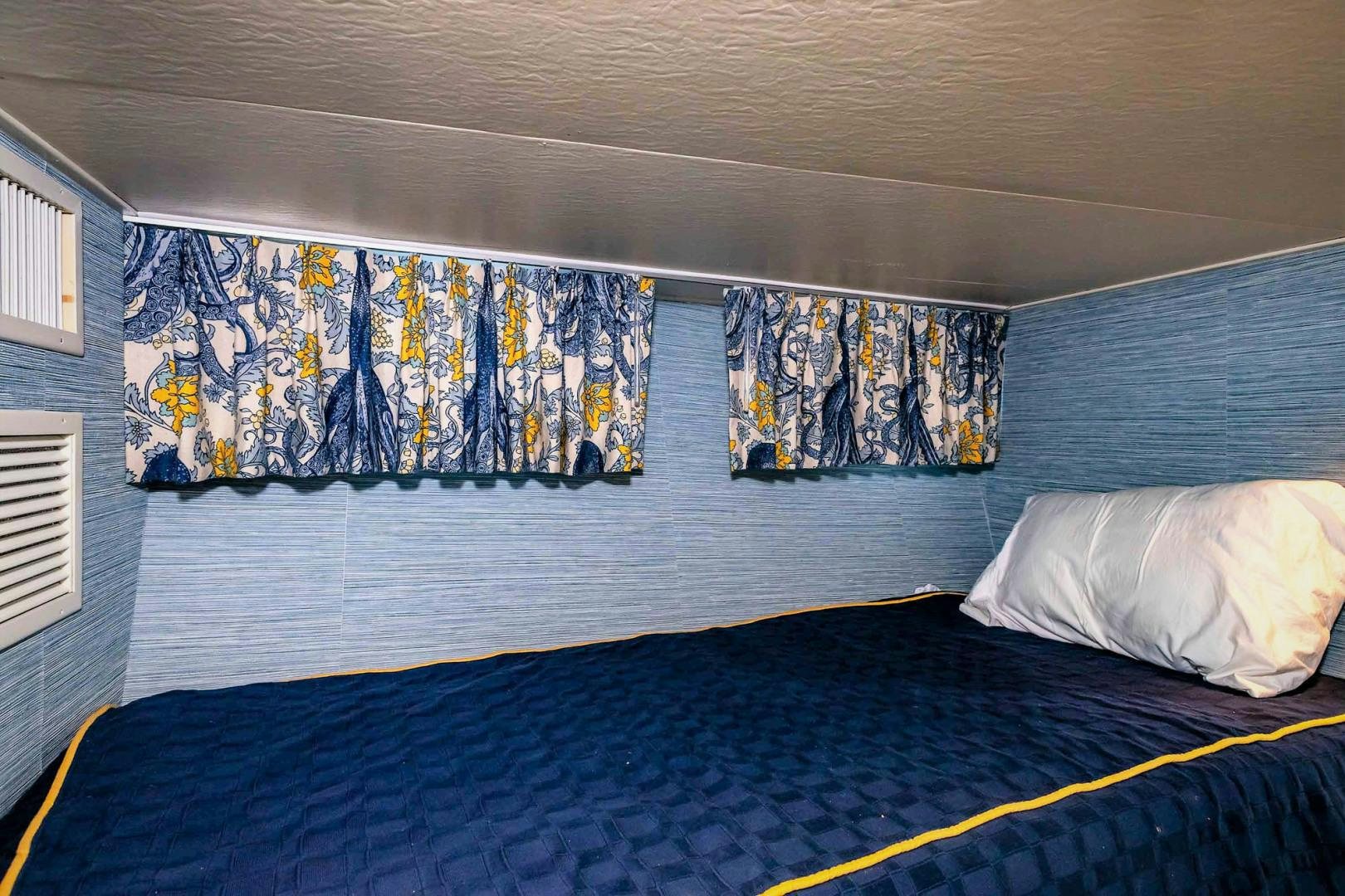 a bed with a blue sheet aboard FREEDOM Yacht for Sale