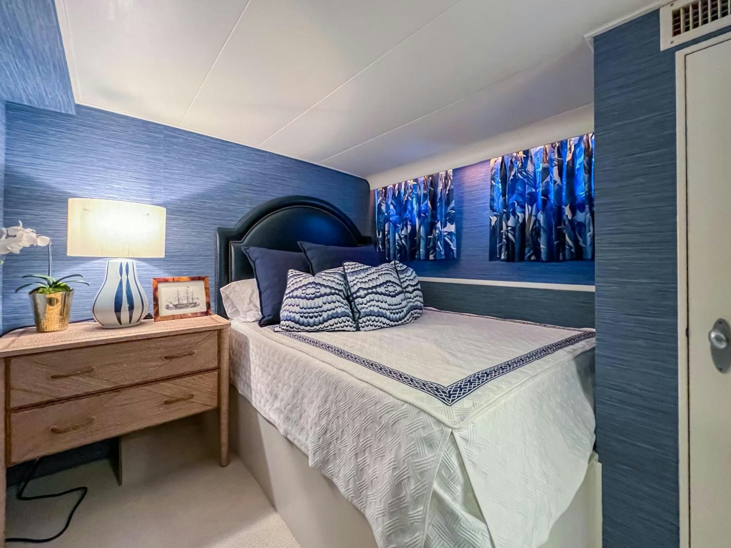 a bedroom with a blue wall aboard FREEDOM Yacht for Sale