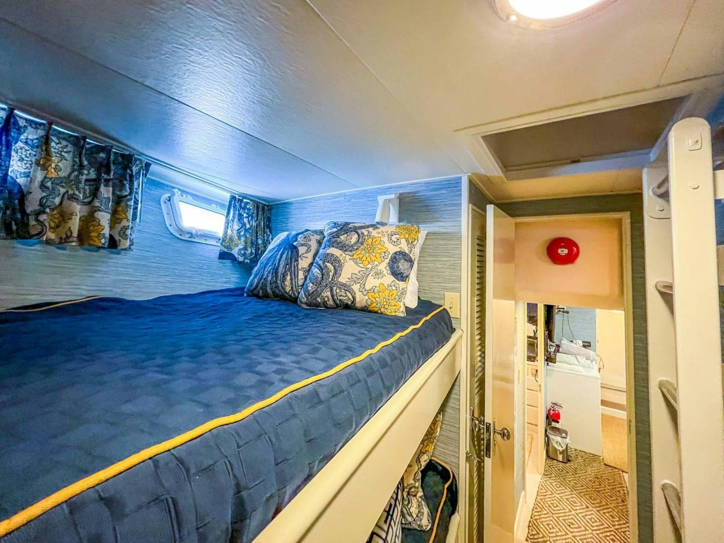 a small bedroom with a blue bed aboard FREEDOM Yacht for Sale