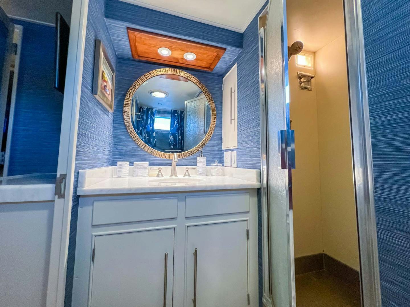 a bathroom with a round mirror aboard FREEDOM Yacht for Sale