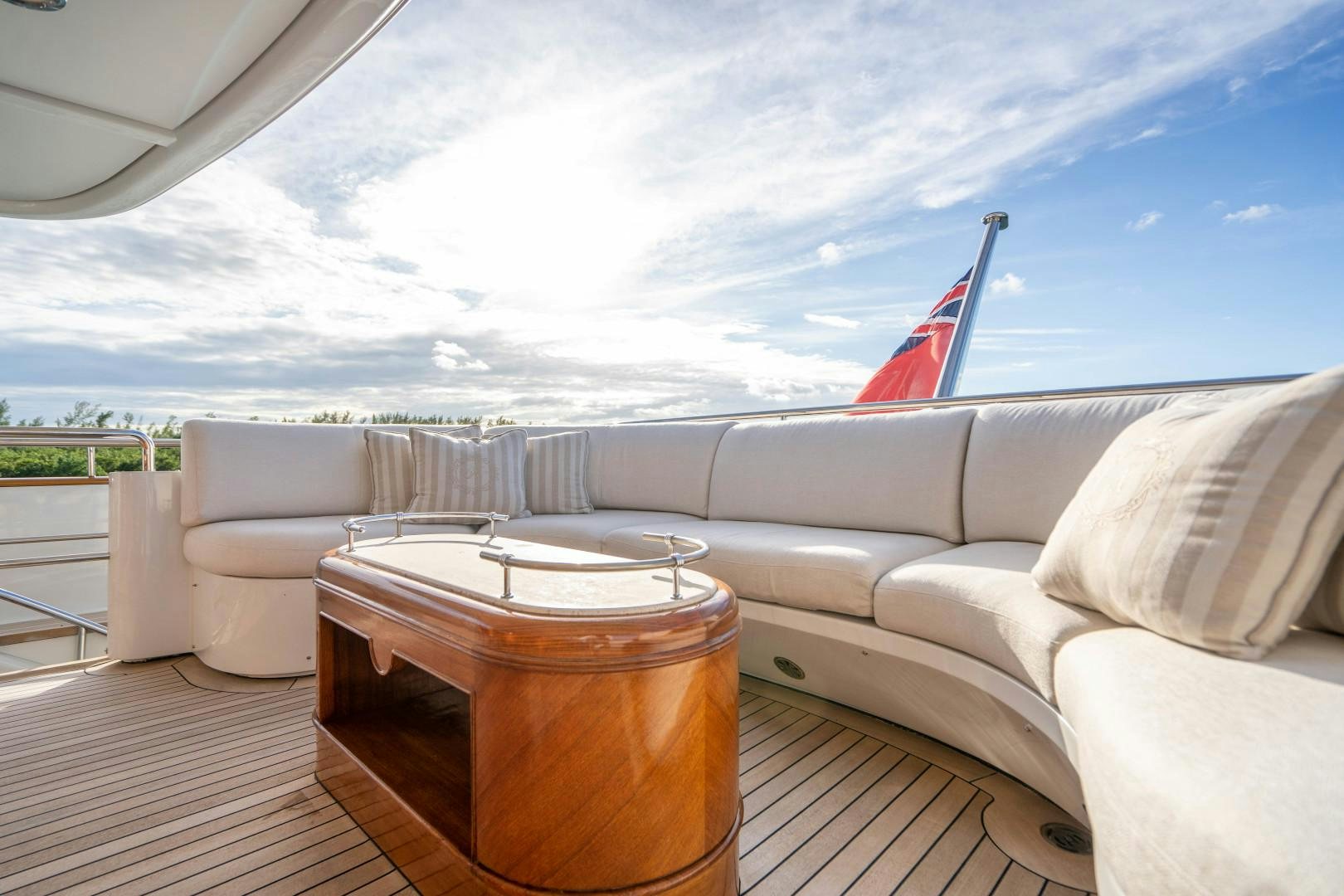 a large sofa and a table on a deck overlooking a body of water aboard ARTEMISEA Yacht for Sale