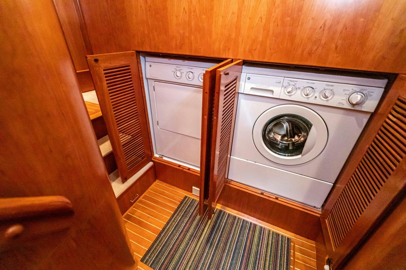 a washing machine in a wooden cabinet aboard TJ SQUARED Yacht for Sale