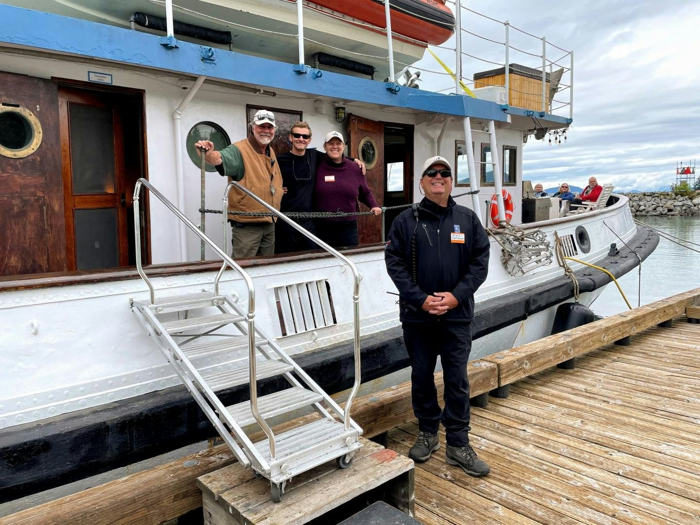 a group of people standing on a boat on a dock aboard SACAJAWEA Yacht for Sale