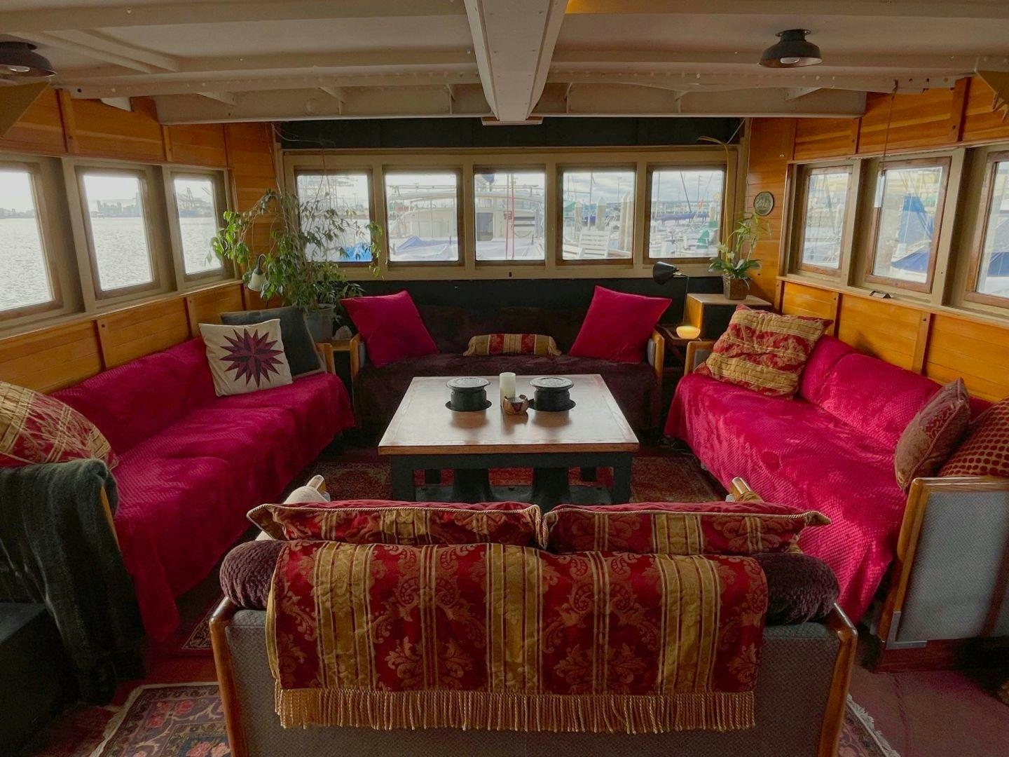 a living room with red couches and a table aboard SACAJAWEA Yacht for Sale