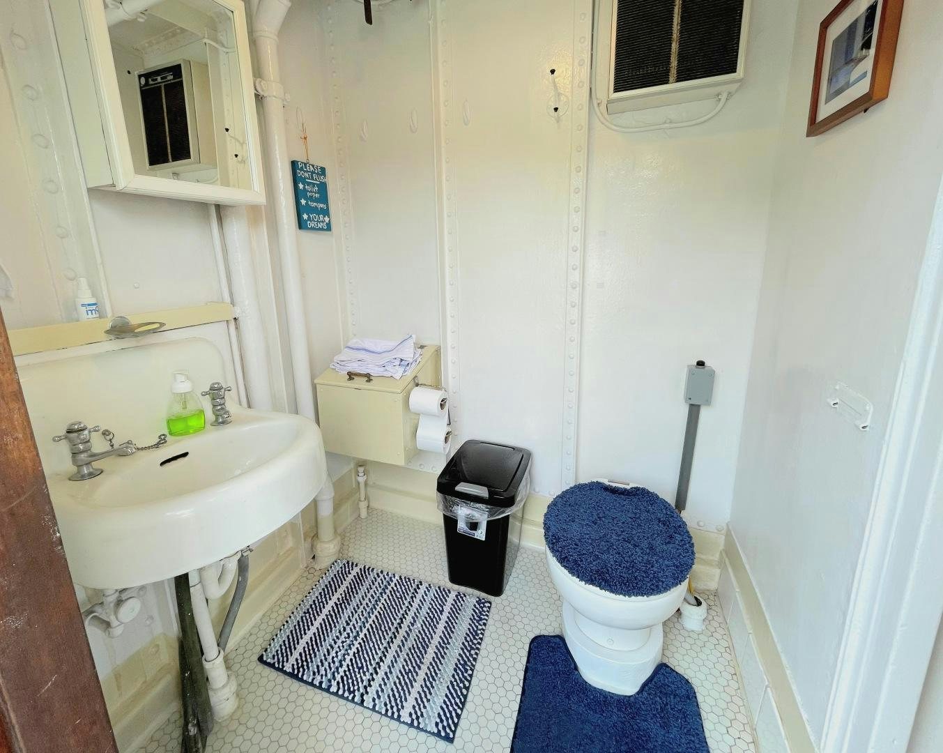 a bathroom with a blue toilet aboard SACAJAWEA Yacht for Sale