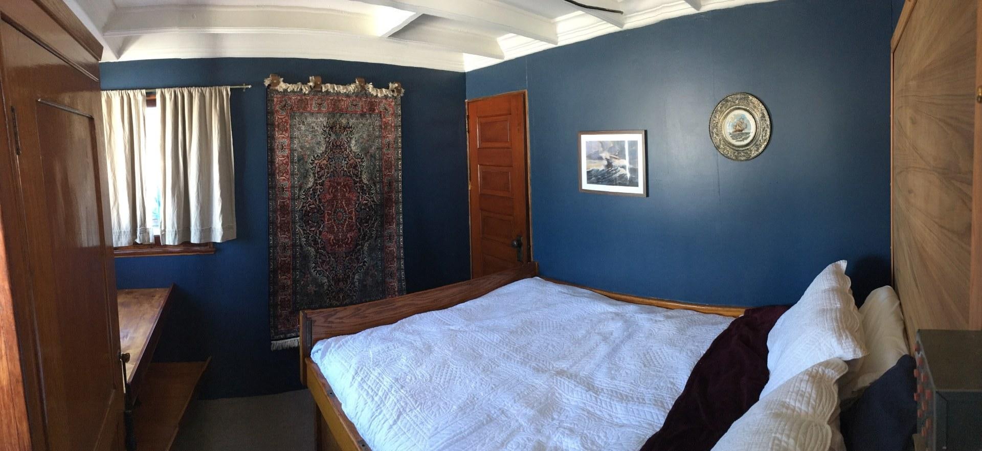 a bedroom with a bed and a coin on the wall aboard SACAJAWEA Yacht for Sale
