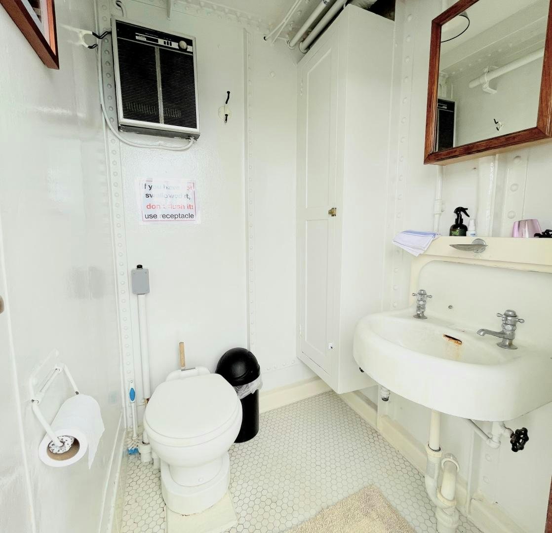 a bathroom with a toilet sink and a mirror aboard SACAJAWEA Yacht for Sale