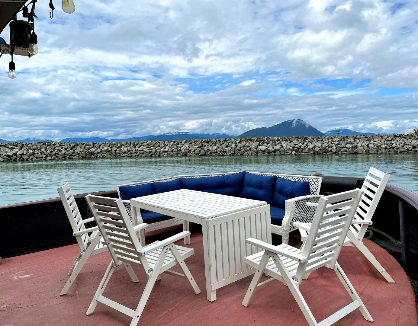 a table and chairs on a deck overlooking a city aboard SACAJAWEA Yacht for Sale